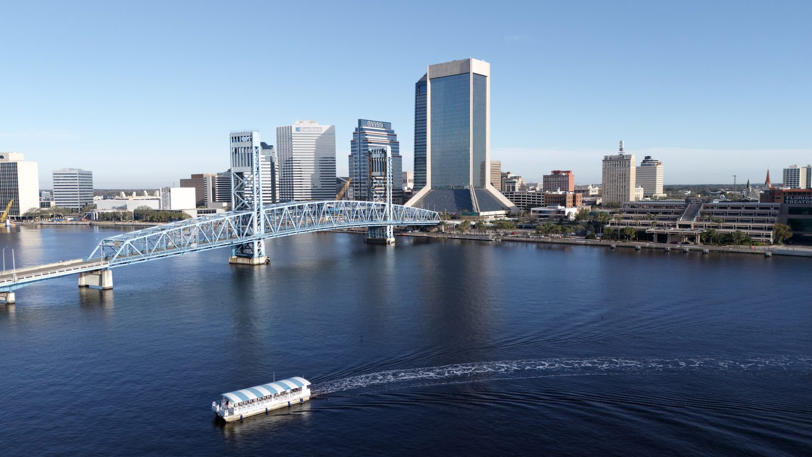 A covered river taxi crossing the St. Johns River near the Main Street Bridge in Jacksonville, Florida